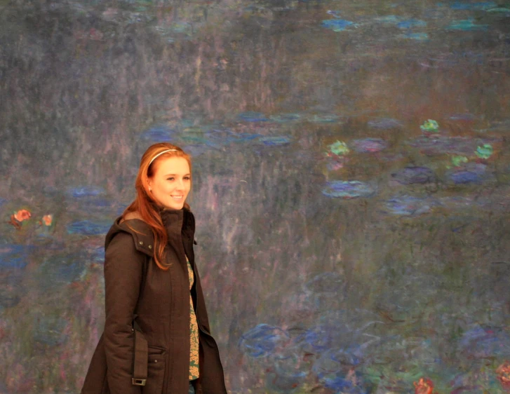 a woman standing in front of waterlilies