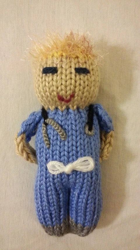 a crocheted stuffed doll in blue pants