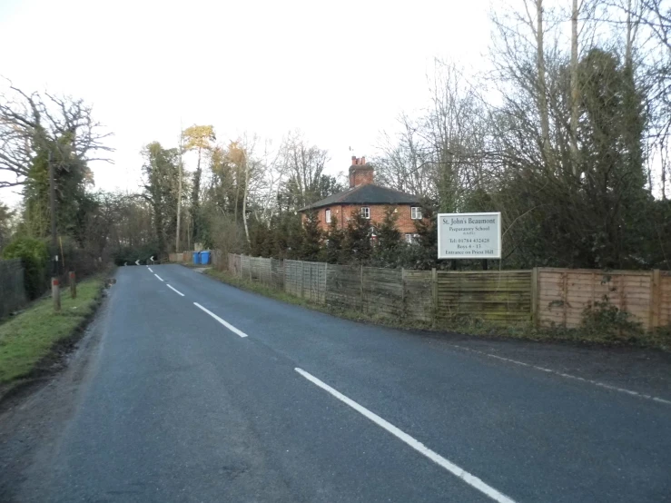 a road leading toward a brown brick house