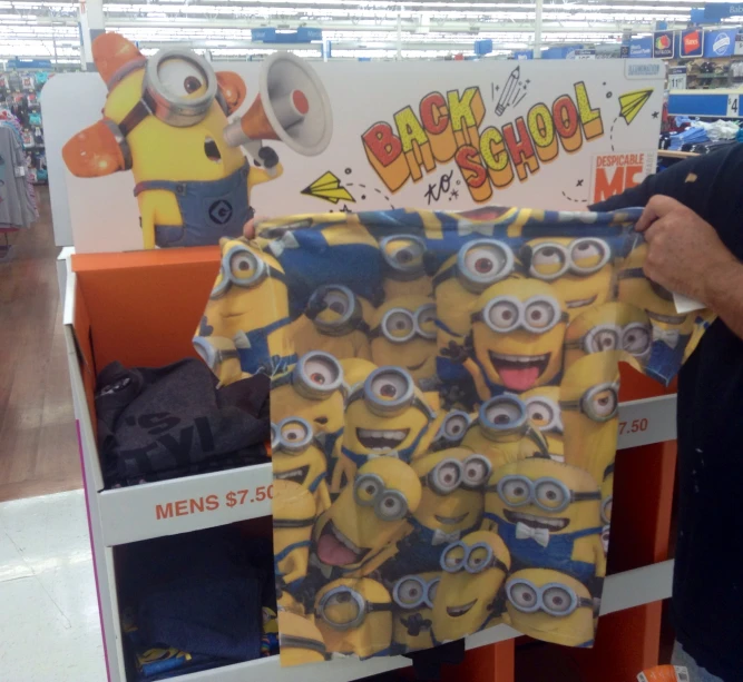 a person holding up a t - shirt that has been made with minion faces