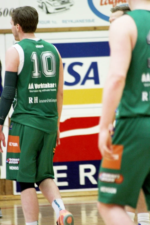 a young man in a green jersey prepares to receive the ball