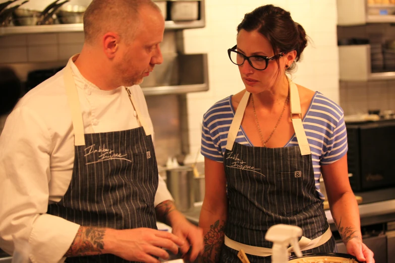 a woman is preparing food in the kitchen with her husband