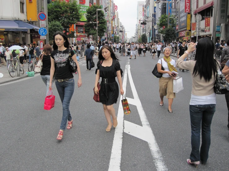 people crossing a city street in the daytime