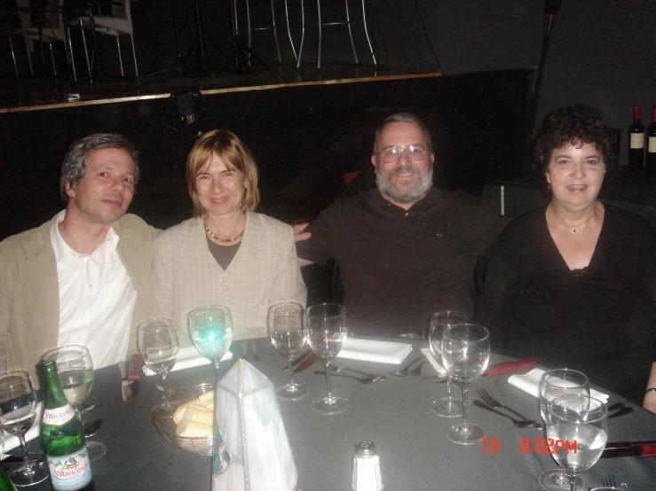 four people posing at a dining table for a po