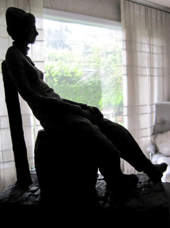 a statue of a woman laying in a chair