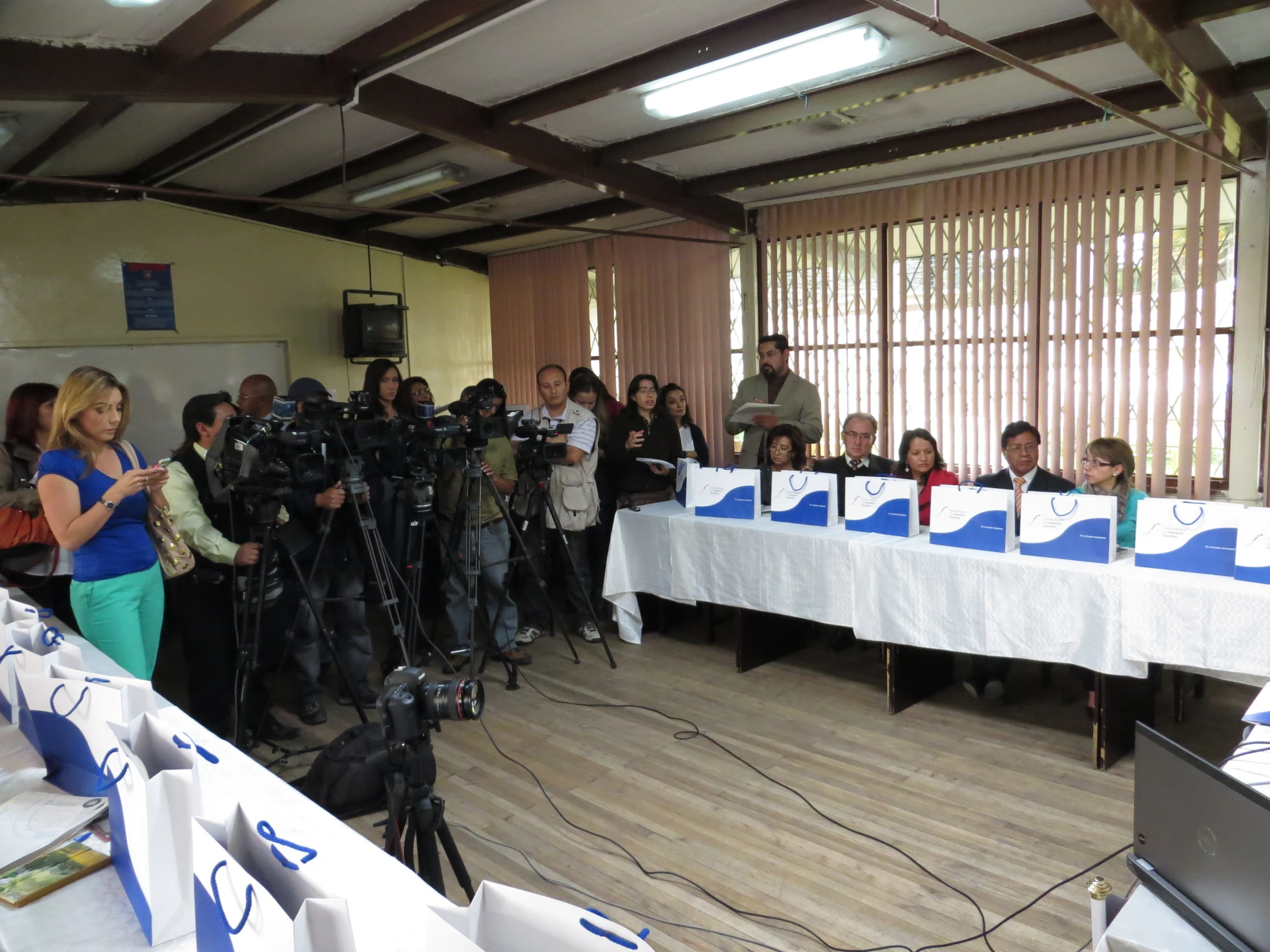 reporters in cameraman's hats with microphones on a table