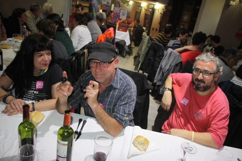 two men are sitting at the table having a drink