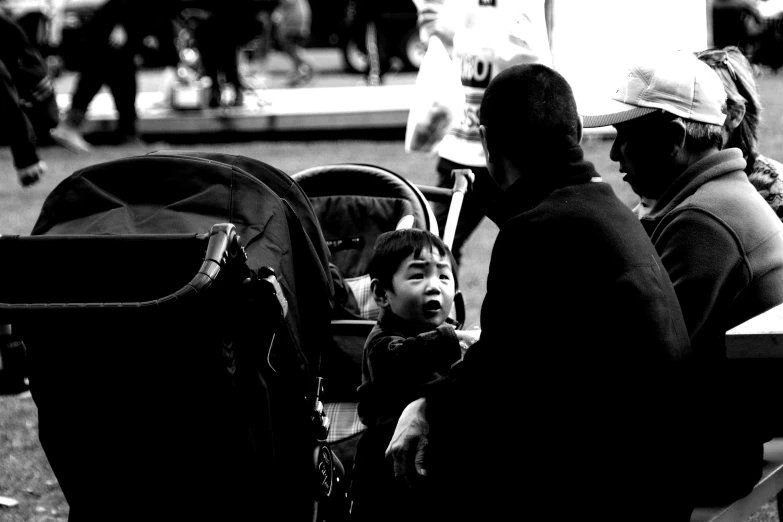 a man sits next to a small child who is sitting down