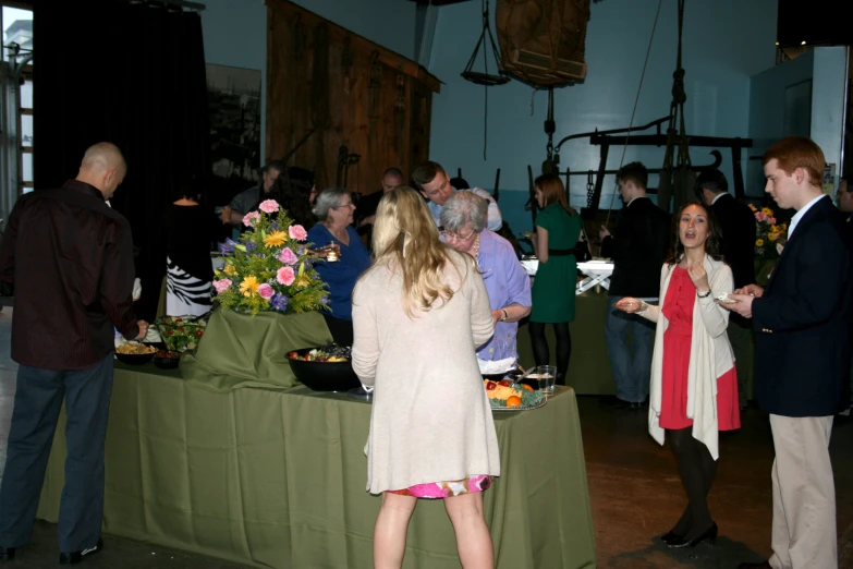 a group of people standing around tables full of food