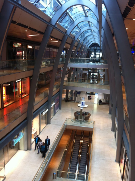 several people on escalators inside of a modern building