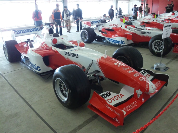 the racing cars are lined up on display at a race track