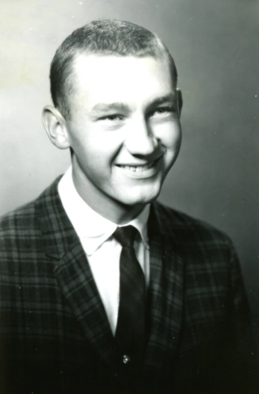 a man with a suit and tie smiles