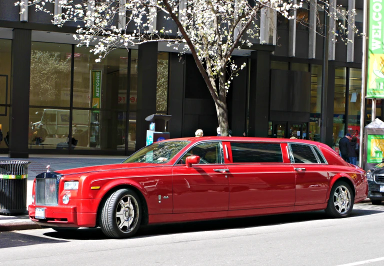 a red stretch limousine parked on a street