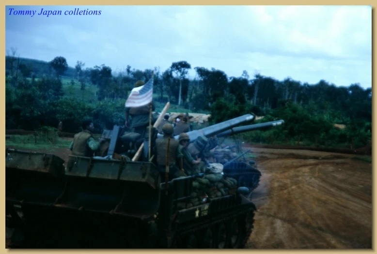 a group of soldiers riding on top of a military tank