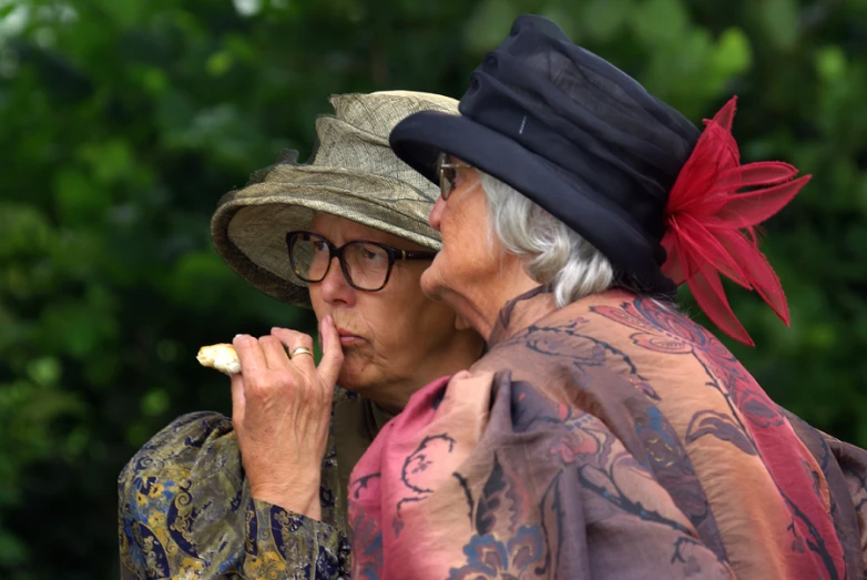 an older couple in dress clothing and hats on a day