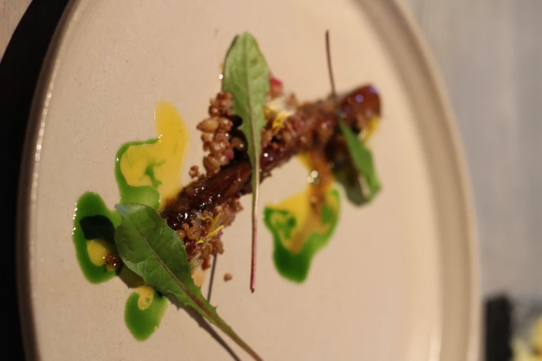 a small white plate with some green garnish on it