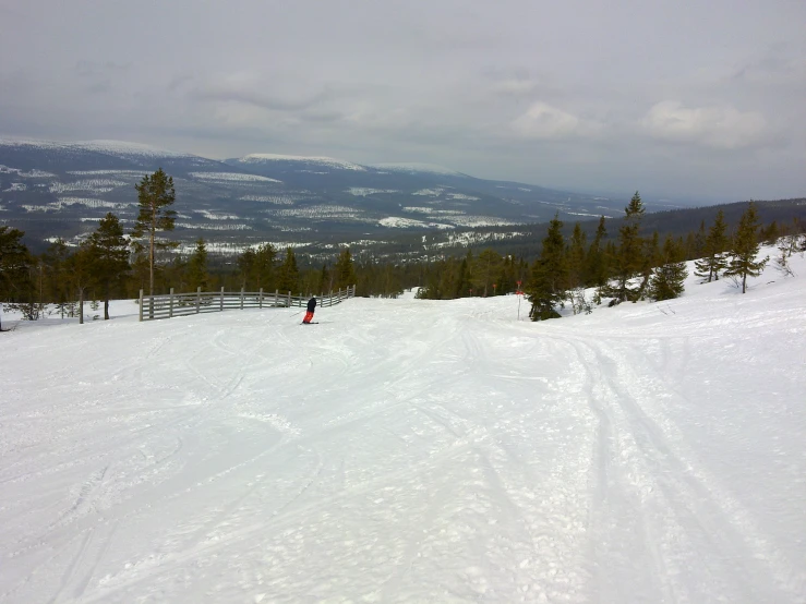 a person skiing on the snow next to mountains