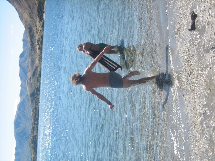 two s in a lake with a surfboard