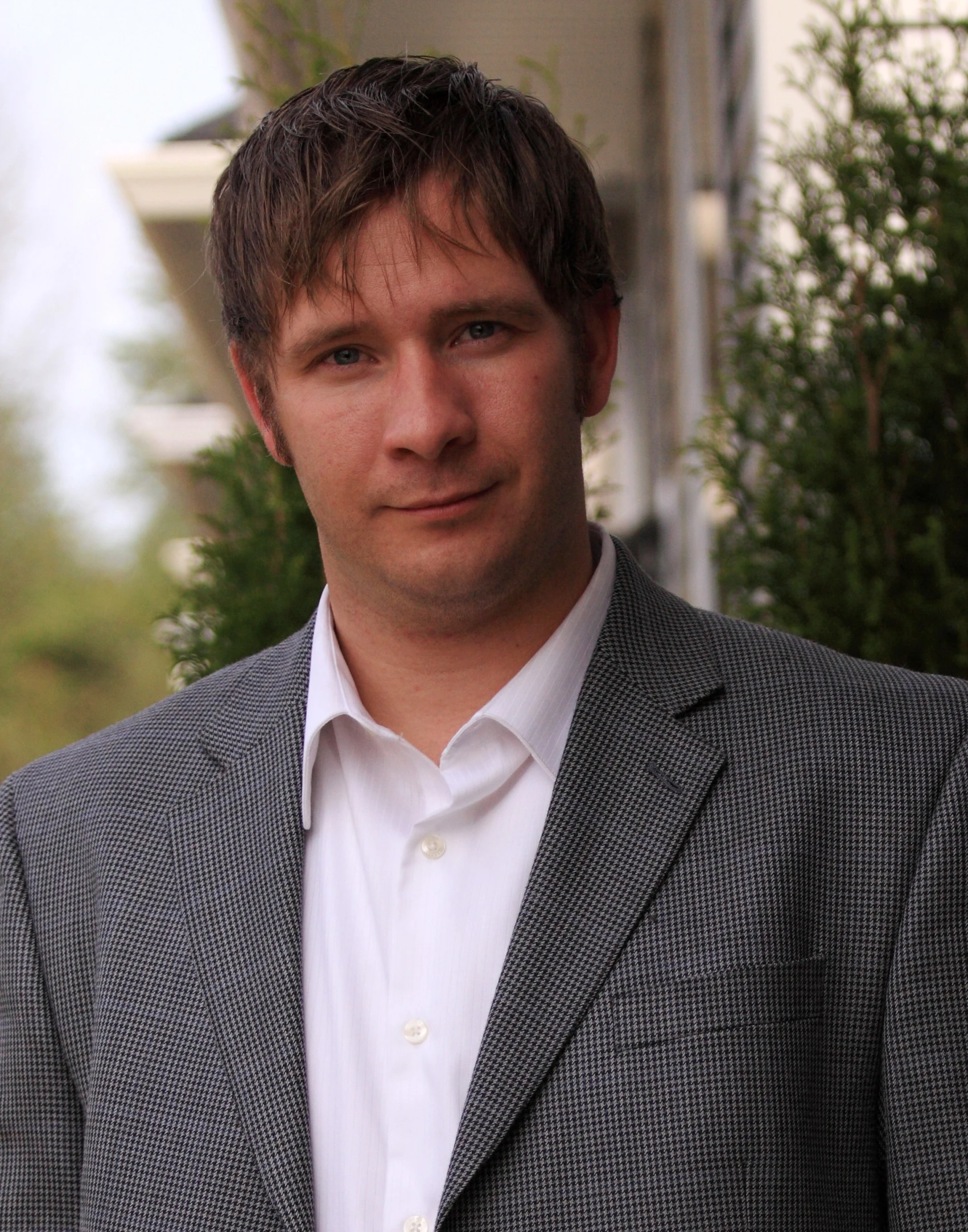 a man in a jacket standing outside with a nice smile on his face