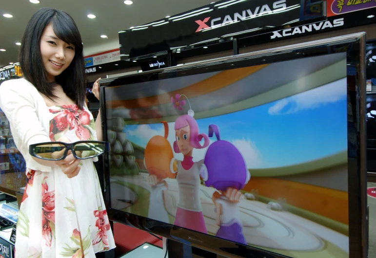 a beautiful woman standing next to a tv screen in a store