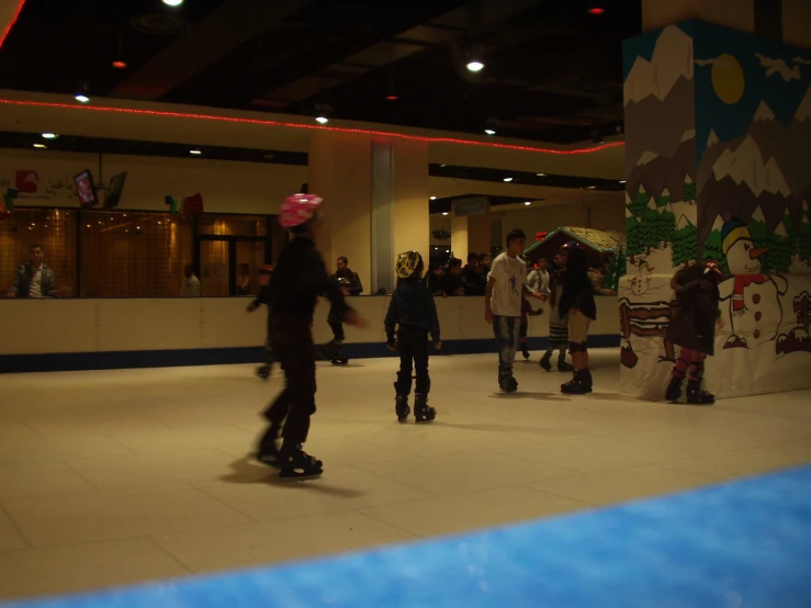 people skate around an indoor skating rink with decorations