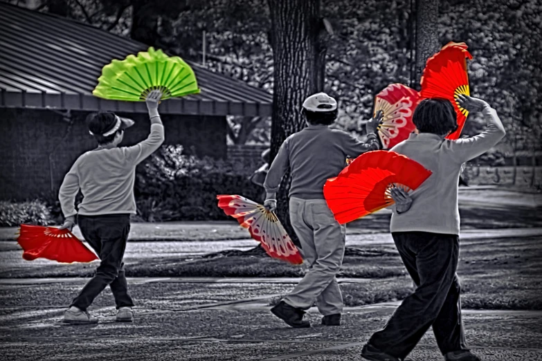 several people carrying decoratively designed red and green fan