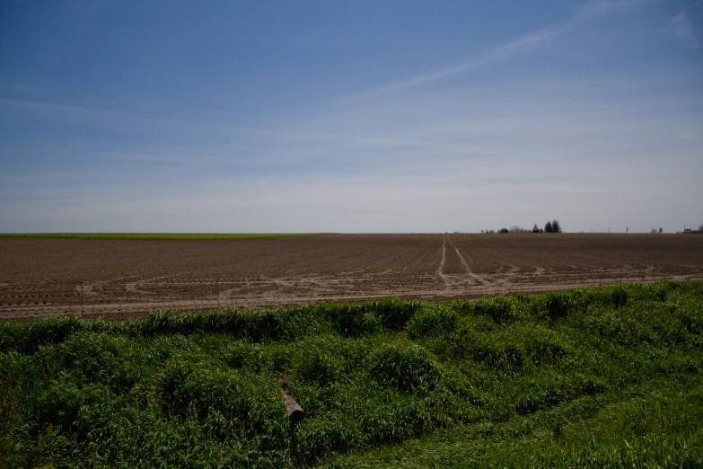 a plowed field and two farm land are shown