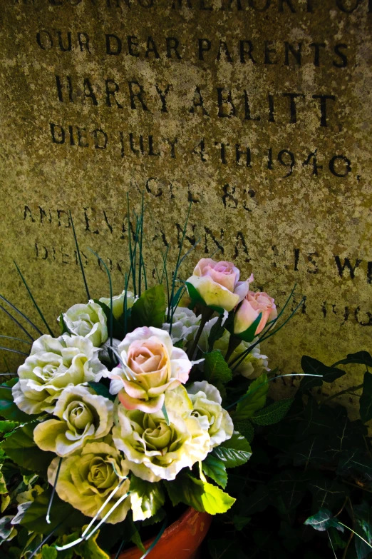 flowers, plants, and twigs decorate the headstone