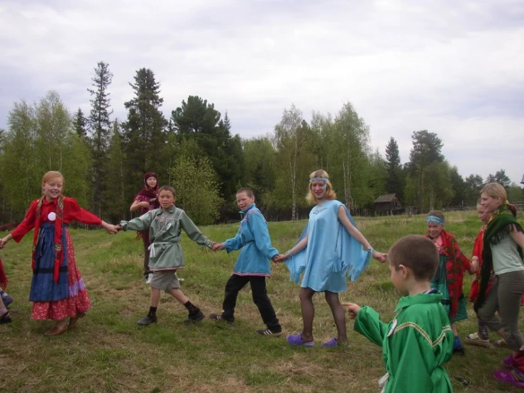 a group of children holding hands as one girl takes a po