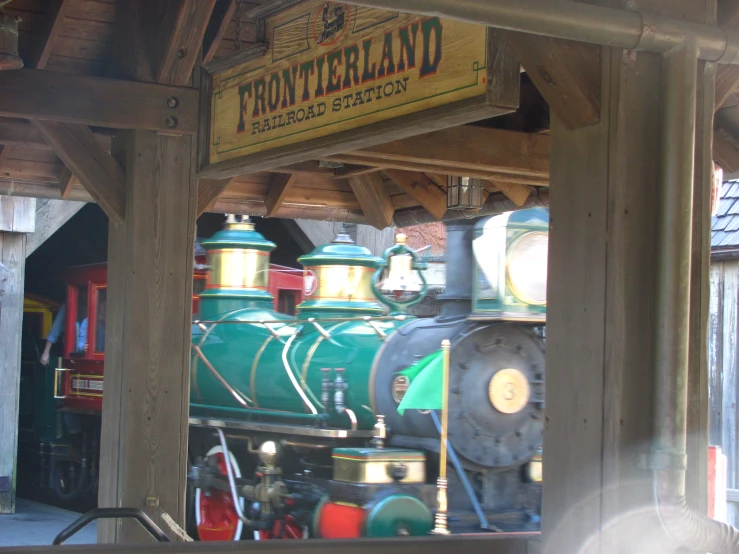 a locomotive with yellow cabooses near a wooden structure