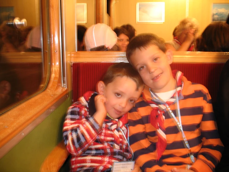 two young children sitting on top of a bench