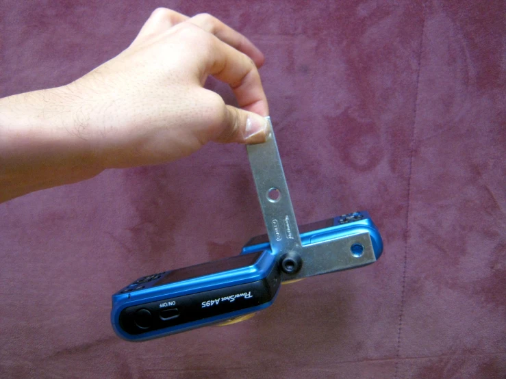 a hand holding a large blue metal pocket knife