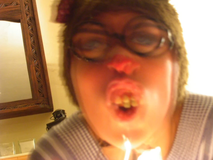 a close up of a person blowing a candle