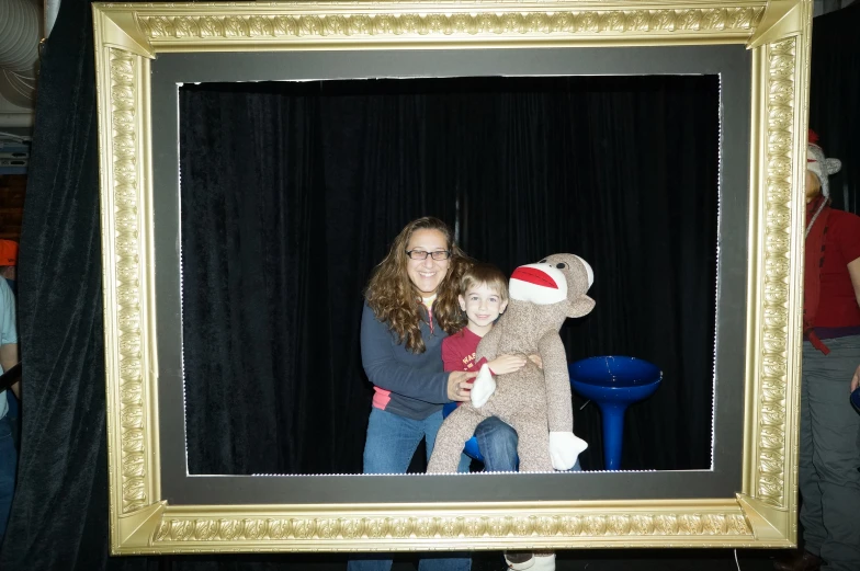 a woman and a child smiling in front of a picture