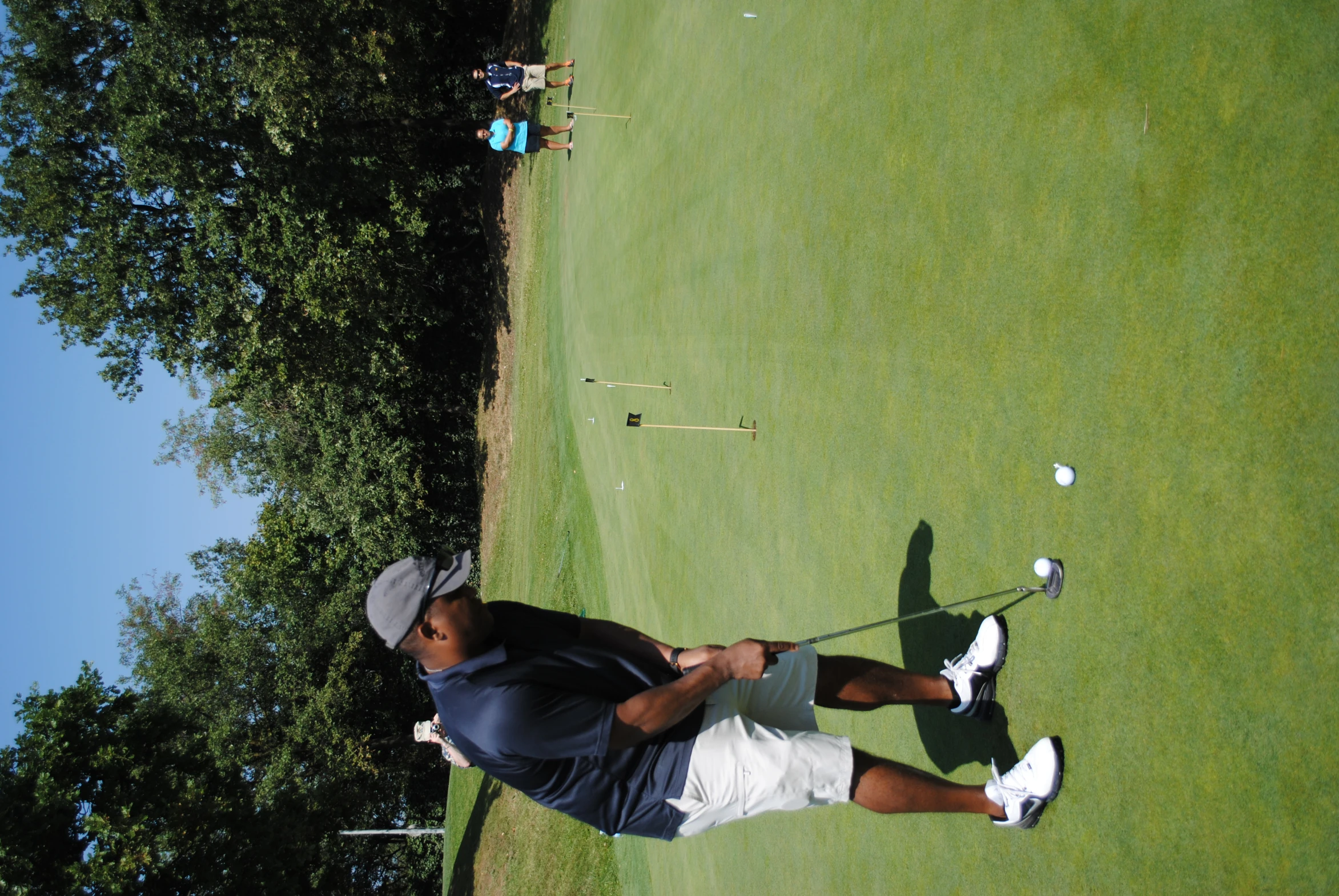 a man on a golf course teeing off a ball