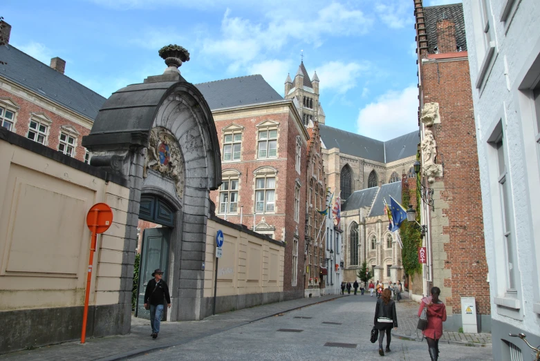 people walk on a paved city street near tall buildings