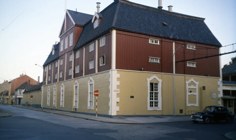 a building with two levels and a car parked in front