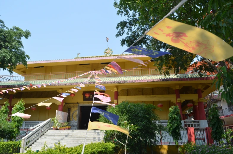 many flags outside of a house by the trees