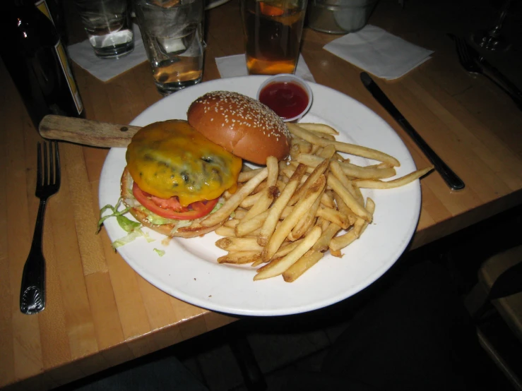 a plate with fries, burger and tomato