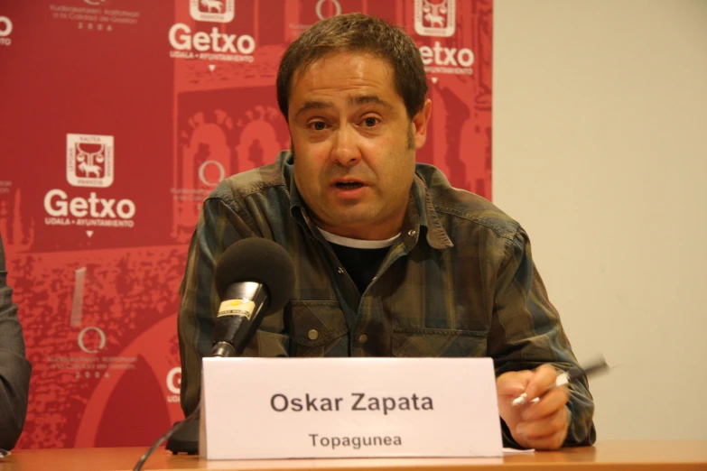 a man is in a brown shirt is sitting at a table