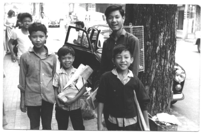 four children standing next to each other near a car