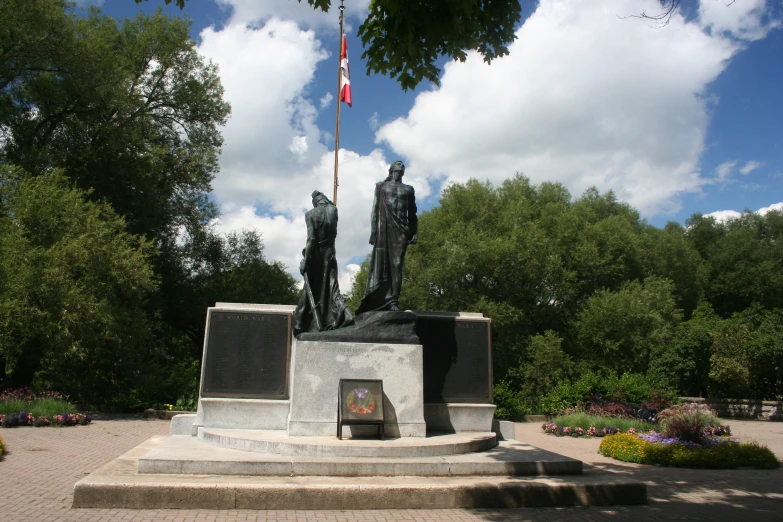 the flags of two men standing in front of a large monument