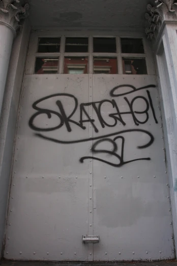 a graffiti filled door on the side of an building