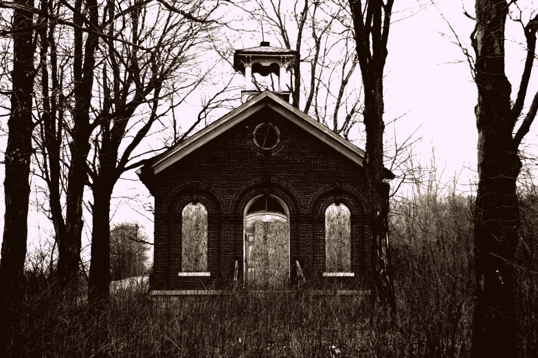 a black and white po of a small chapel in a forest