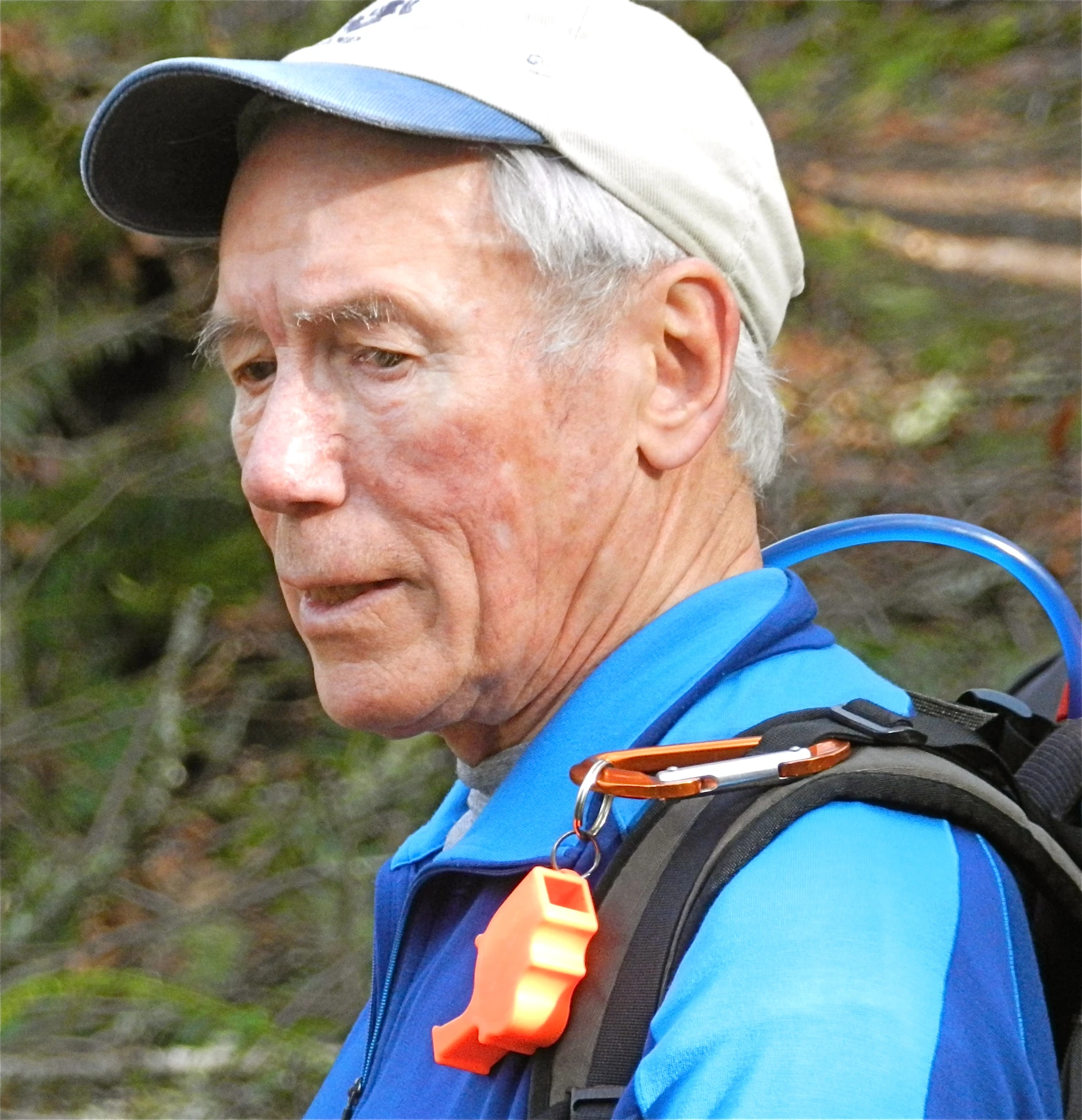 an older man with a backpack in the woods