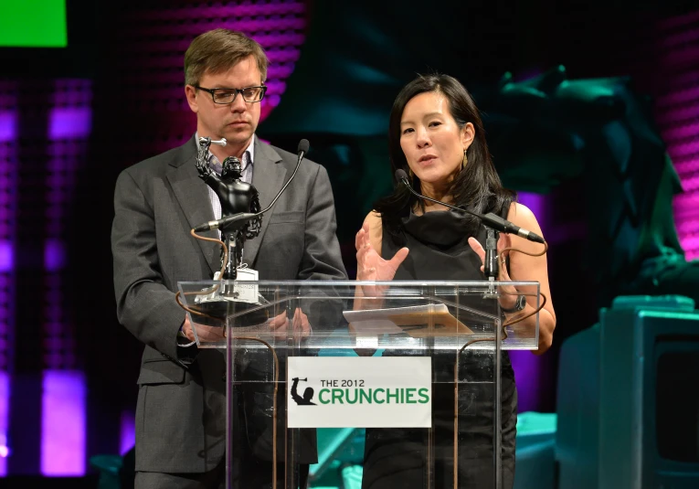 a man and woman standing next to each other behind a podium