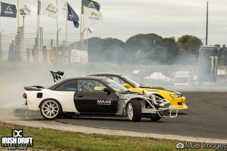 a race car turning around a track with smoke behind it