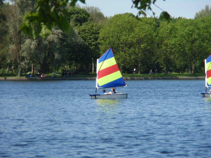two colorful sailboats floating on the water