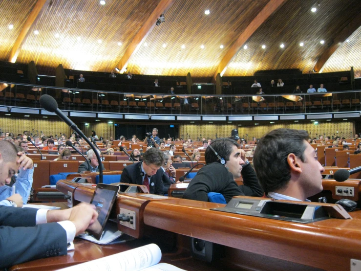 audience members taking notes in an auditorium with laptops