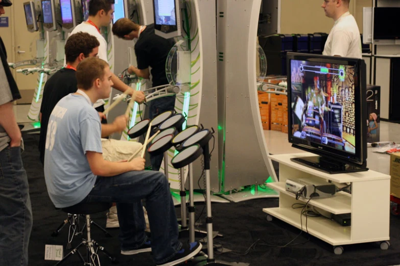 a group of men standing around a tv screen